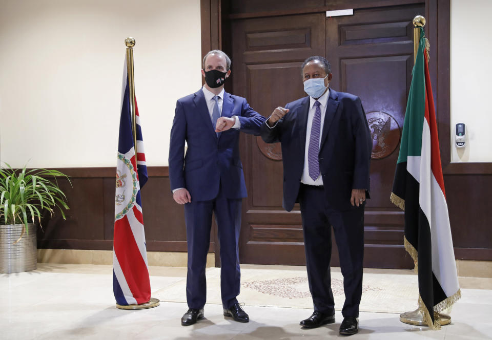 Sudanese Prime MInister Abdullah Hamdok, right, bumps elbows with British Foreign Secretary, Dominic Raab in the Cabinet Building, in Khartoum, Sudan, Thursday, Jan. 21, 2021. Raab was in the Sudanese capital Thursday to discuss bilateral relations and tensions along the border with Ethiopia, Sudan's state news agency reported. (AP Photo)