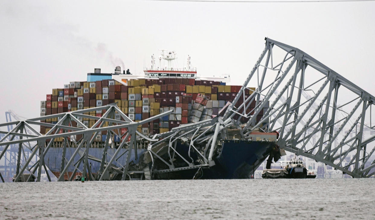 A cargo ship is stuck under the part of the structure of the Francis Scott Key Bridge after the ship hit the bridge Wednesday, March 27, 2024, in Baltimore, Md. (AP Photo/Steve Helber)