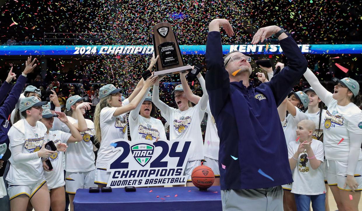 Kent State women's basketball coach Todd Starkey signals for the confetti to fall as his players celebrate winning the Mid-American Conference Tournament championship on Saturday.