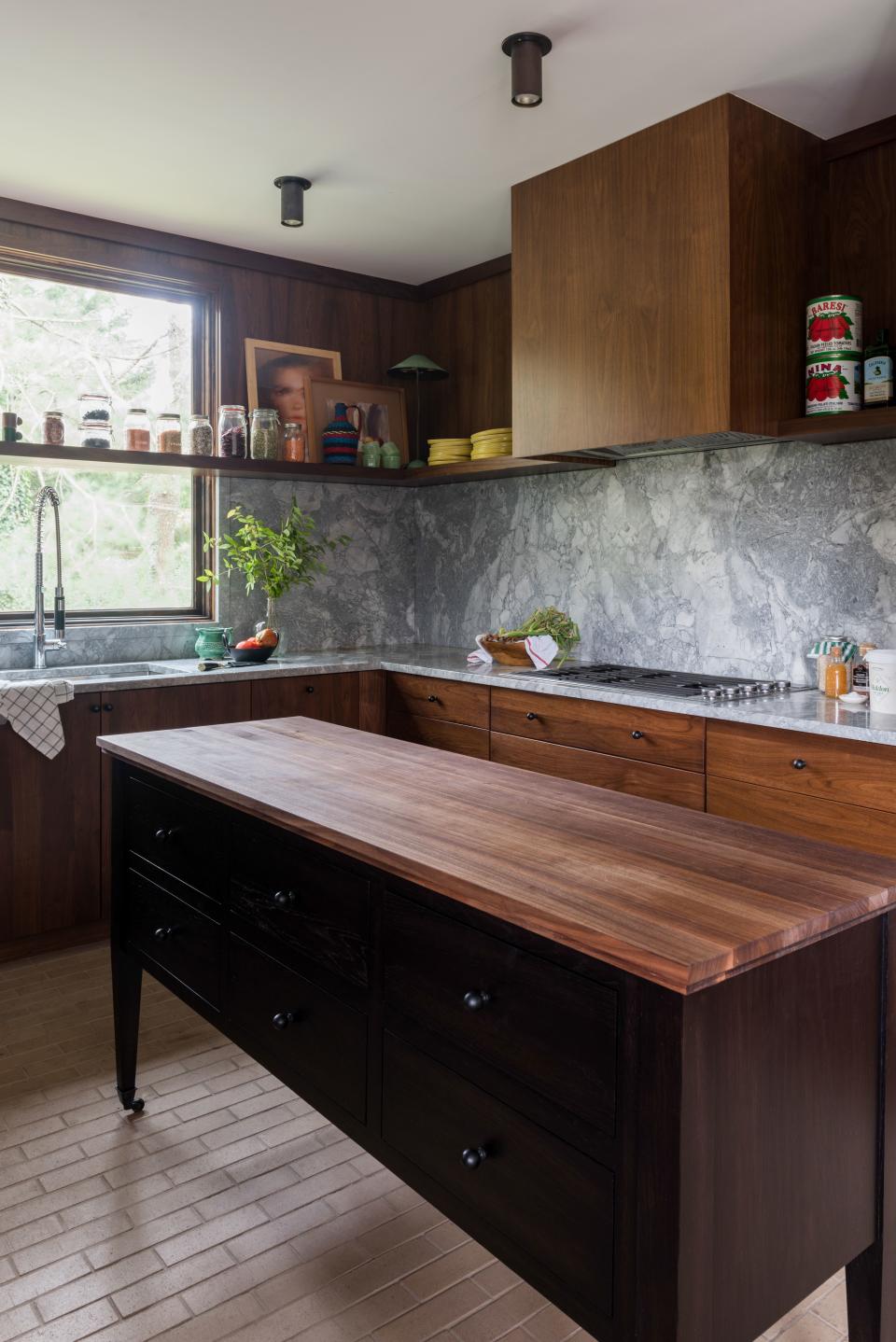 A 22-inch black oak island, complete with cutting-board top, functions as an additional work surface and a storage space for cooking tools and utensils.