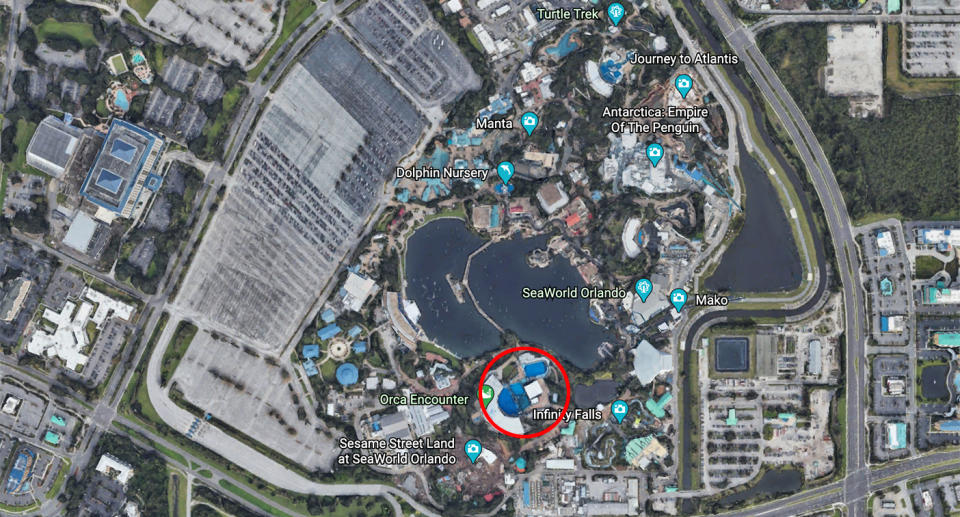 A Google Earth image of SeaWorld Orlando with the orca attraction highlight with a red circle. On the left of the image is the much larger carpark.