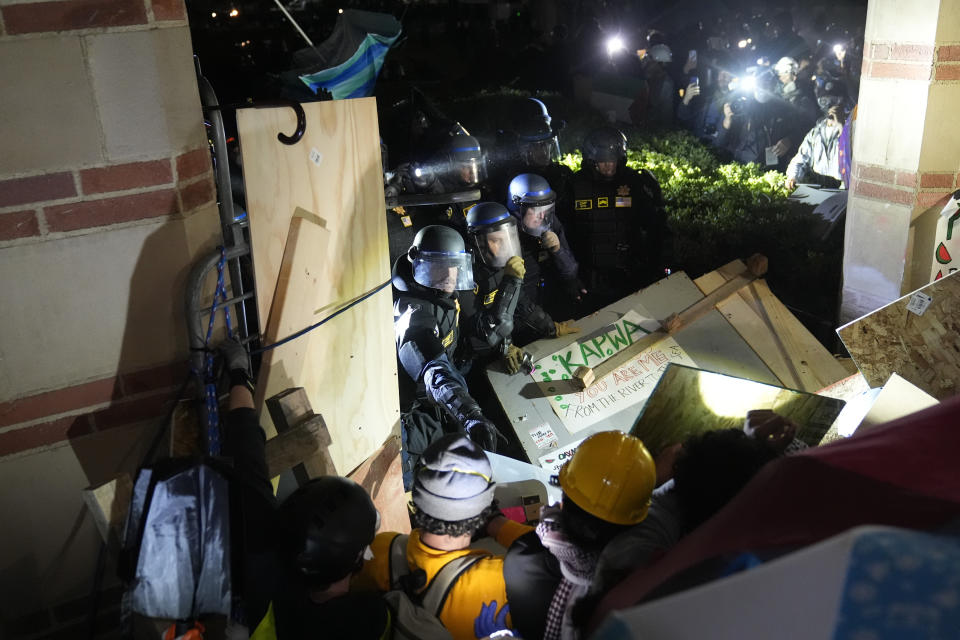 Police break through a barrier set up by pro-Palestinian demonstrators on the UCLA campus Thursday, May 2, 2024, in Los Angeles. (AP Photo/Jae C. Hong)