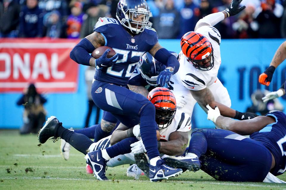 Cincinnati Bengals nose tackle D.J. Reader (98) tackles Tennessee Titans running back Derrick Henry (22) in the first quarter during an NFL divisional playoff football game, Saturday, Jan. 22, 2022, at Nissan Stadium in Nashville.