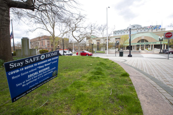 A sign announcing the mayor&#39;s stay at home order due to the coronavirus pandemic is seen on a lawn across the street from the Margaret E. Morton Government Center in downtown in Bridgeport, Conn, Monday, April 27, 2020. (AP Photo/Mary Altaffer)