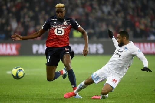 Victor Osimhen (L) of Lille is tackled by Jordan Amavi of Marseille