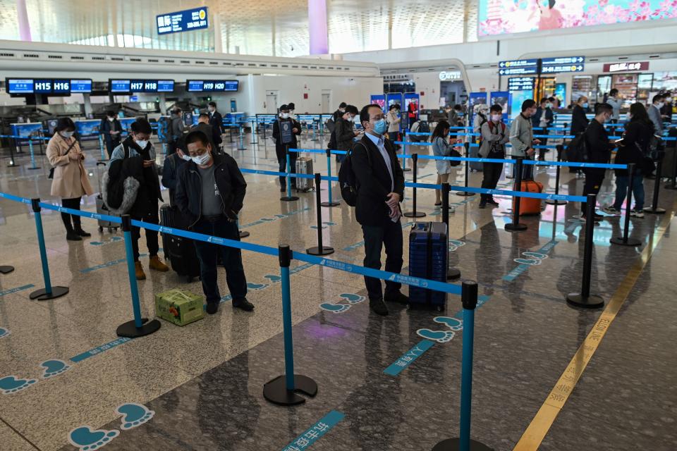 Passengers wearing face masks wait at Wuhan Tianhe International Airport after it was reopened.