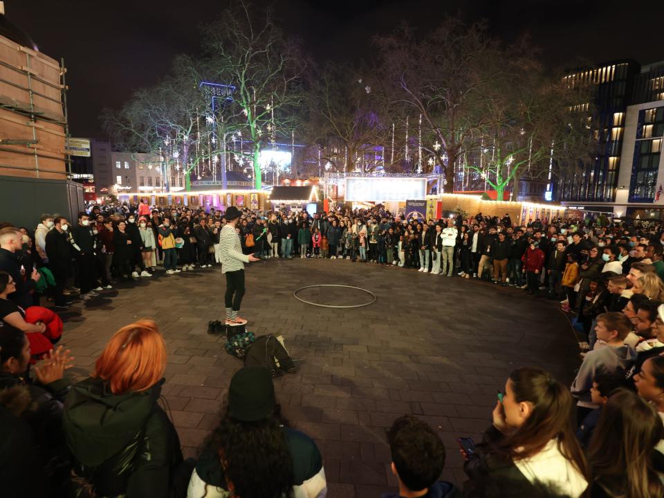 Crowds form around a street performer ahead of New Year's Eve celebrations in Leicester Square, central London (James Manning/PA)