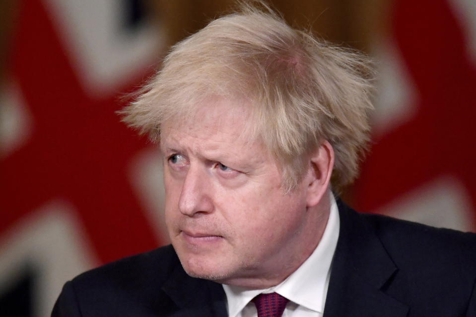 Britain's Prime Minister Boris Johnson speaks during a news conference in response to the ongoing situation with the coronavirus (COVID-19) pandemic, inside 10 Downing Street, London, Saturday, Dec. 19, 2020. Johnson says Christmas gatherings can’t go ahead and non-essential shops must close in London and much of southern England as he imposed a new, higher level of coronavirus restrictions to curb rapidly spreading infections. (Toby Melville/Pool Photo via AP)