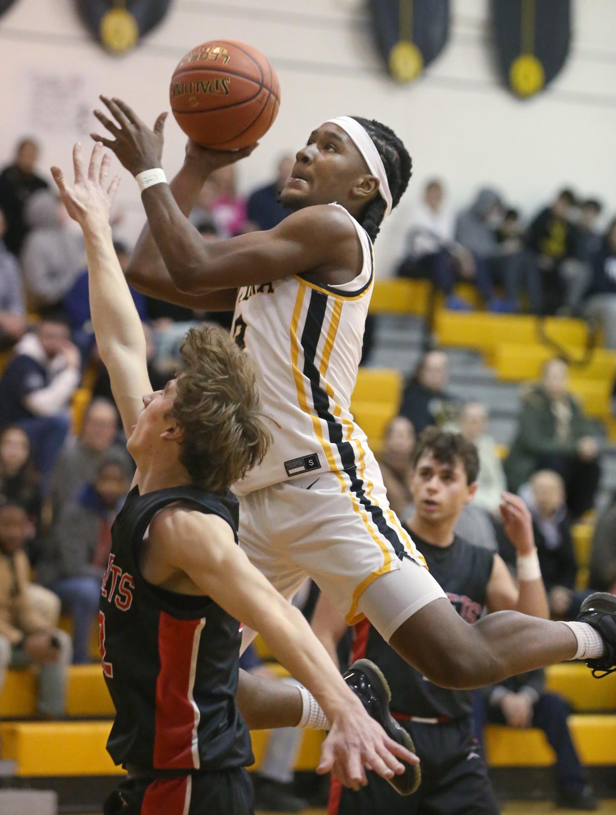 Greece Athena's I'zayah Reaves drives to the basket over Hilton Central's Jack Smith in the opening quarter during their Section V boys basketball non-league game Tuesday, Feb. 6, 2024 at Greece Athena High School. Athena won the close game 59-56.