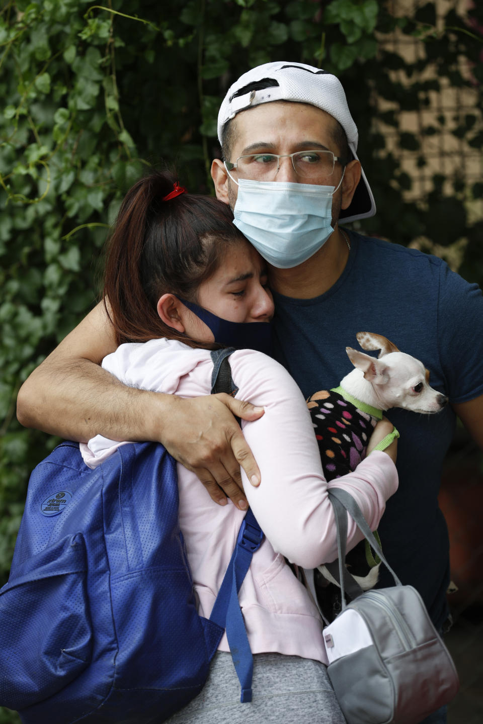 A couple embraces outside their home as they wait for the all-clear to return to their apartment, after an earthquake in Mexico City, Tuesday, June 23, 2020. The earthquake struck near the Huatulco resort in southern Mexico on Tuesday morning, swayed buildings in Mexico City and sent thousands fleeing into the streets. (AP Photo/Eduardo Verdugo)