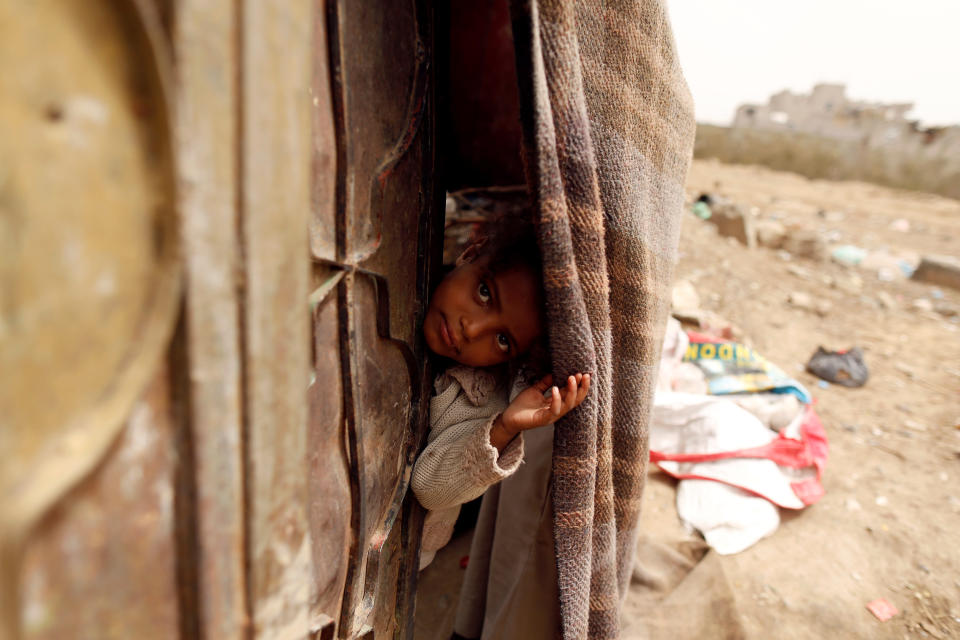 <p>A girl displaced from the Red Sea port city of Hodeidah looks from behind a door of her family shelter in Sanaa, Yemen July 18, 2018. (Photo: Khaled Abdullah/Reuters) </p>