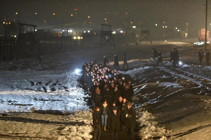 Poland's President Bronislaw Komorowski (C) and guests walk in a procession to light candles on a memorial for the victims after the main ceremony to mark the 70th anniversary of the liberation of the Auschwitz death camp on January 27, 2015 (AFP Photo/Janek Skarzynski)