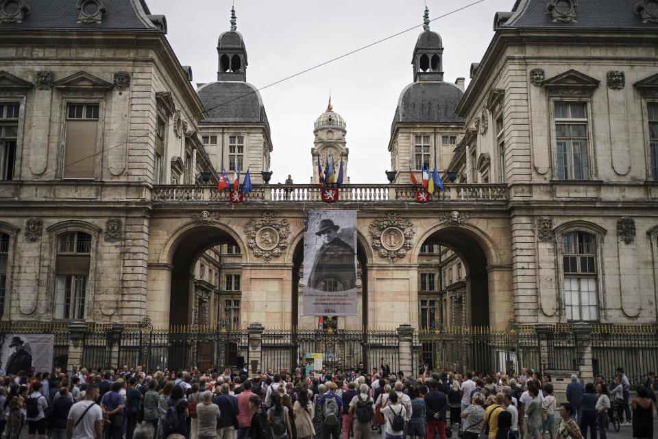 People gather in front of the city hall Monday, July 3, 2023 in Lyon, central France, in a show of solidarity with the mayor of the Paris suburb of L'Hay-les-Roses after a burning car struck his home. Unrest across France sparked by the police shooting of a 17-year-old appeared to slow on its sixth night, but still public buildings, cars and municipal trash cans were targeted nationwide by fires and vandalism overnight into Monday. (AP Photo/Laurent Cipriani)