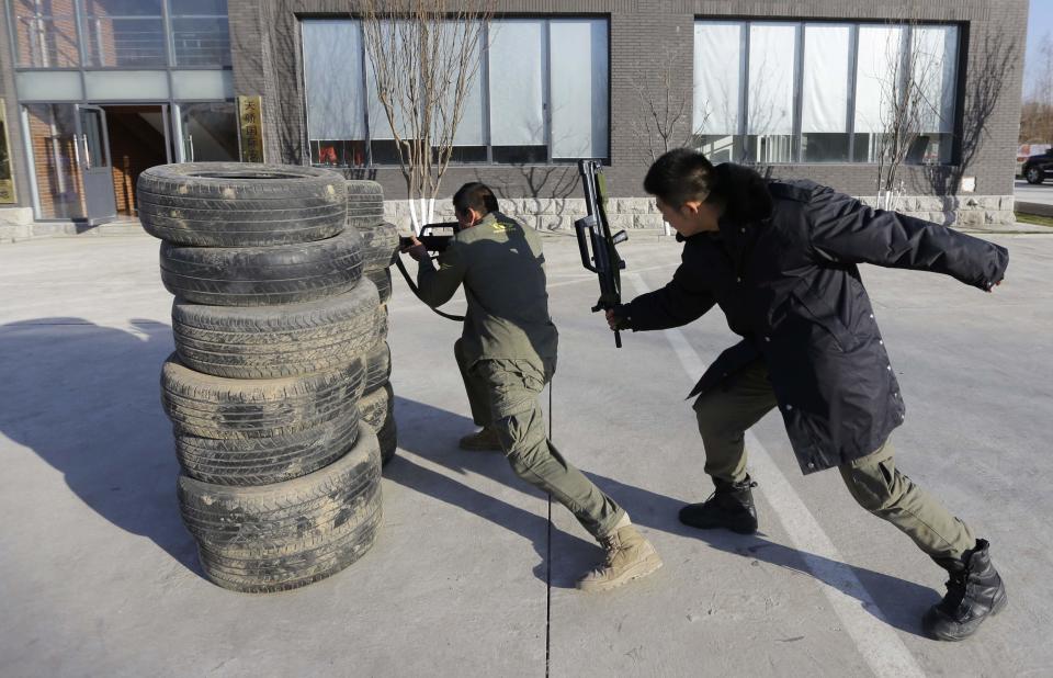 Instructor hits trainee with a replica 95 semi-automatic rifle during training at the Tianjiao Special Guard/Security Consultant training camp on the outskirts of Beijing