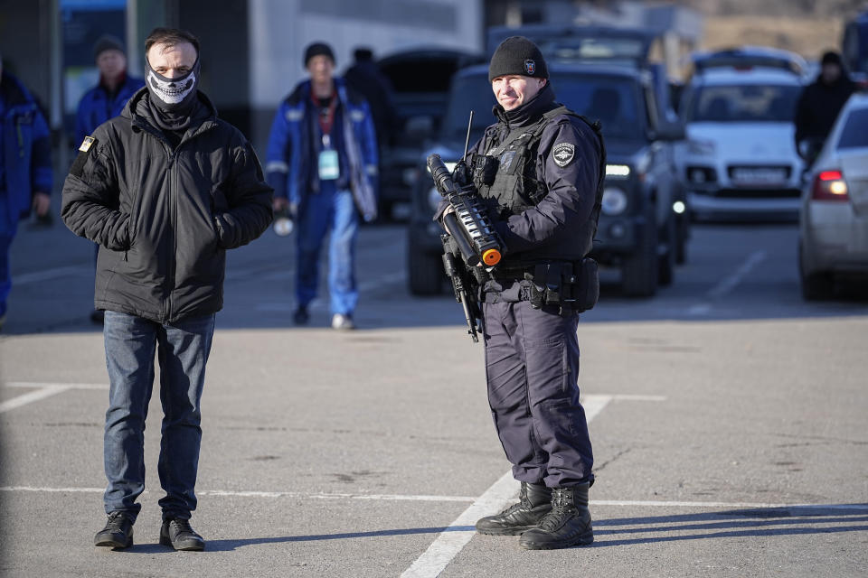 A police officer stands guard holding an anti-drone rifle in the outskirts of Moscow, Russia, Monday, March 25, 2024 near the Crocus City Hall, which was hit by a terrorist attack on Friday. There were calls Monday for harsh punishment for those behind the attack on the Rossiya concert hall that killed more than 130 people as authorities combed the burnt-out ruins of the shopping and entertainment complex in search of more bodies. (AP Photo/Alexander Zemlyanichenko)