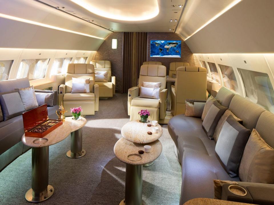 داخل طيران الإمارات ACJ319 مع أرائك وكراسي استلقاء وطاولات.