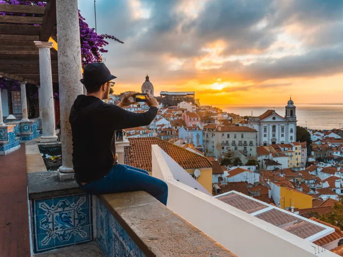 A tourist photographs the sunrise in Lisbon, Portugal, ranked as the top city in the world for remote workers.