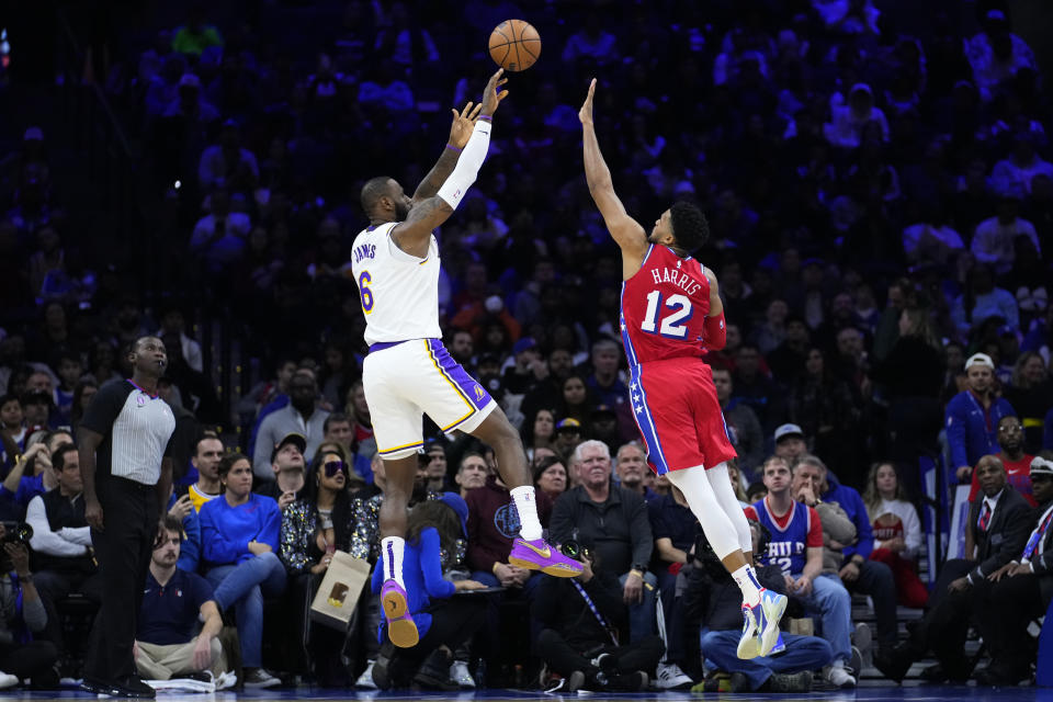 Los Angeles Lakers' LeBron James, left, goes up for a shot against Philadelphia 76ers' Tobias Harris during the first half of an NBA basketball game, Friday, Dec. 9, 2022, in Philadelphia. (AP Photo/Matt Slocum)