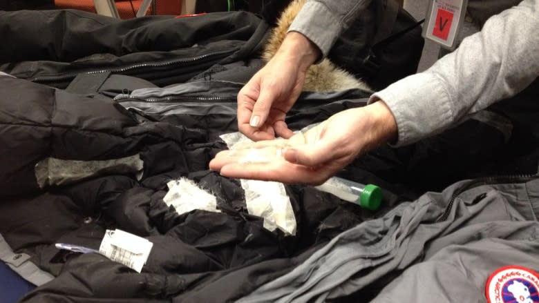 Duck feathers found inside counterfeit Canada Goose jackets are shown at a RCMP press conference on Thursday.