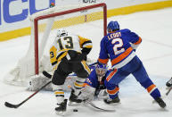 New York Islanders goaltender Ilya Sorokin (30) makes a save as Pittsburgh Penguins left wing Brandon Tanev (13) threatens with Islanders defenseman Nick Leddy (2) defending the crease during the third period of an NHL hockey game, Sunday, Feb. 28, 2021, in Uniondale, N.Y. (AP Photo/Kathy Willens)