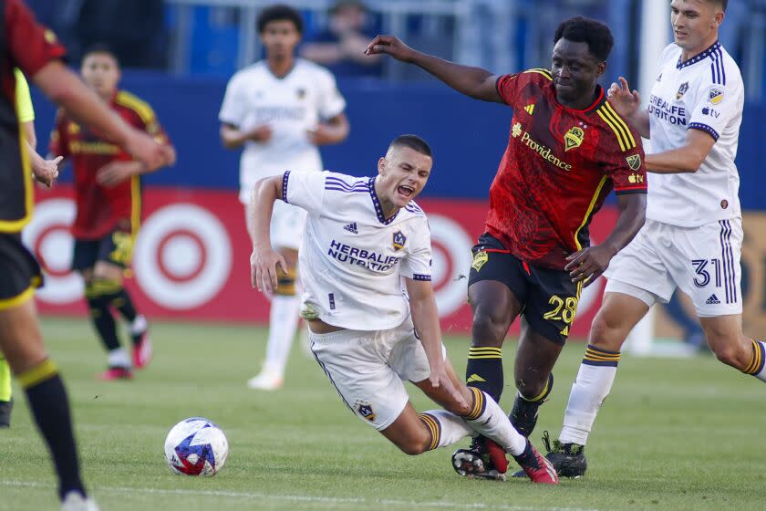 The Galaxy's Dejan Joveljic, middle, is tackled by the Sounders' Yeimar Gómez Andrade (28) on April 1, 2023.