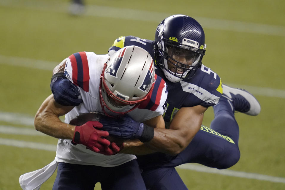 Seattle Seahawks middle linebacker Bobby Wagner, right, tackles New England Patriots wide receiver Julian Edelman during the second half of an NFL football game, Sunday, Sept. 20, 2020, in Seattle. The Seahawks won 35-30. (AP Photo/Elaine Thompson)