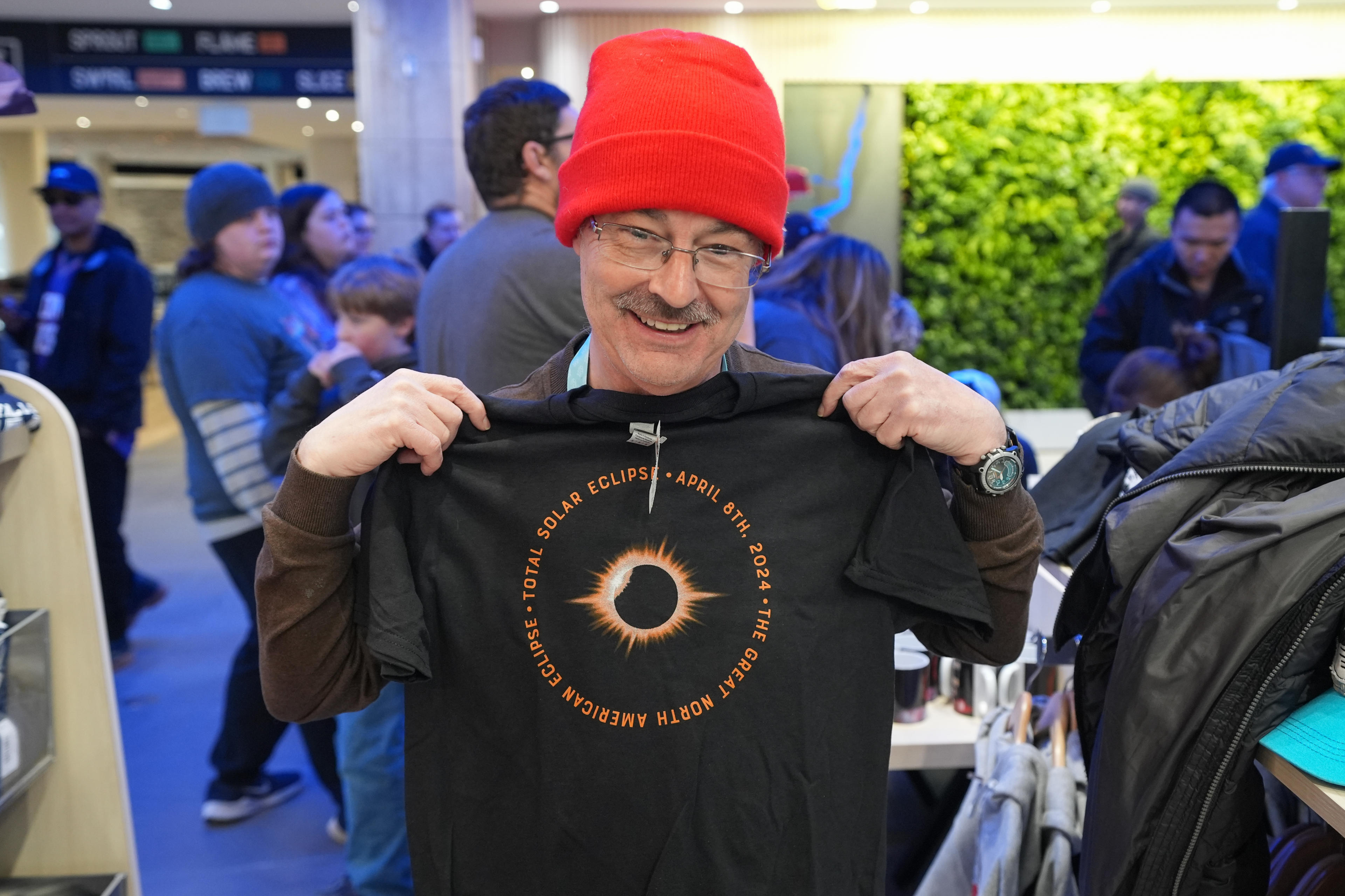 A man holding a solar eclipse tshirt poses for a photo at Niagara Falls State Park ahead of a total solar eclipse across North America on April 8, 2024 in Niagara Falls, Ontario,Canada. (Mert Alper Dervis/Anadolu via Getty Images)