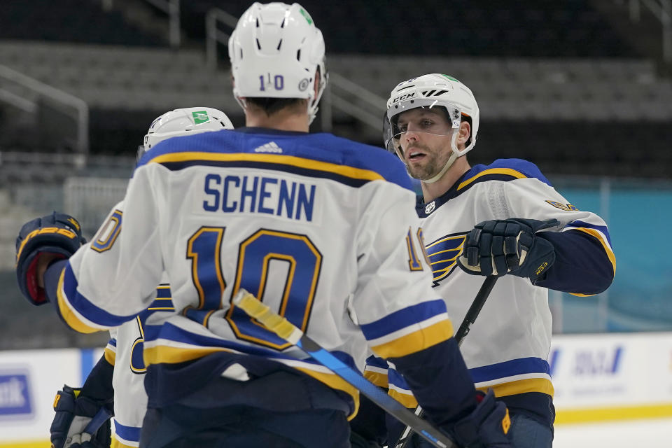 CORRECTS TO SCHENN SCORED NOT PERRON - St. Louis Blues left wing David Perron, right, celebrates with Brayden Schenn (10) and teammates after Schenn scored against the San Jose Sharks during the second period of an NHL hockey game in San Jose, Calif., Monday, March 8, 2021. (AP Photo/Jeff Chiu)
