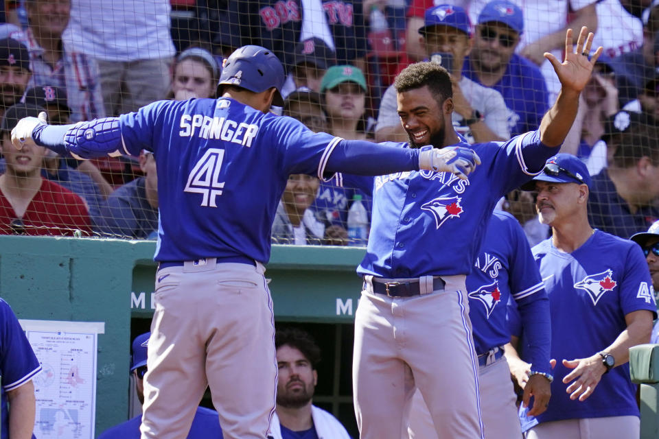Toronto Blue Jays' George Springer (4) celebrates with Teoscar Hernandez, right, after his solo home run off Boston Red Sox starting pitcher Garrett Richards during the fifth inning of a baseball game at Fenway Park, Wednesday, July 28, 2021, in Boston. (AP Photo/Charles Krupa)