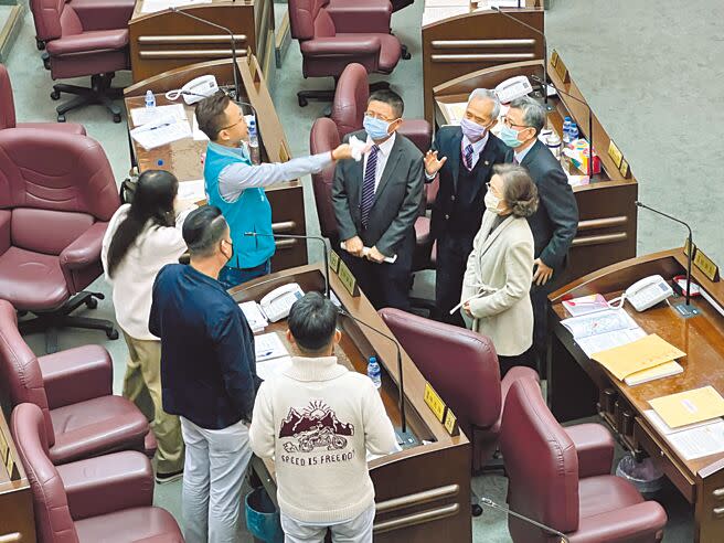 桃市府副市長王明鉅祕書曾妍潔，7日朝議事堂拍攝錄影，引爆綠營議員怒火，王明鉅（右一戴綠口罩者）中場休息時間連忙道歉。（蔡依珍攝）