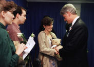 FILE - In this Sunday, April 23, 1995 file photo, Aren Almon of Oklahoma City, clutches a teddy bear as she is greeted by President Bill Clinton in Oklahoma City, Okla., after a prayer service for the victims of Wednesday's deadly car bomb attack in downtown Oklahoma City. Almon's 1-year old daughter, Baylee, was killed in the attack. The pandemic is playing out in a divided country under a president who thrives on rousing his supporters and getting a rise out of those who don't like him, whether that means forgoing a mask, playing golf while millions hunker down or thrashing opponents on Twitter. (AP Photo/Pat Sullivan)