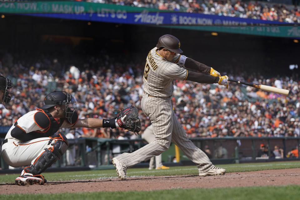 San Diego Padres' Manny Machado hits a two-run single in front of San Francisco Giants catcher Curt Casali during the eighth inning of a baseball game in San Francisco, Thursday, Sept. 16, 2021. (AP Photo/Jeff Chiu)