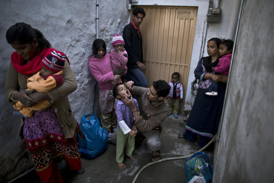 FILE - in this file photo taken Monday, Nov. 25, 2013, Pakistani health worker, Nooman Mehboob, 21, center, gives Ameeq Andriaz, 4, a polio vaccine, while other women holding their children wait to have them vaccinated in a neighborhood in Islamabad, Pakistan. The World Health Organization said the northwestern Pakistani city of Peshawar has become the largest poliovirus reservoir in the world. (AP Photo/Muhammed Muheisen, File)