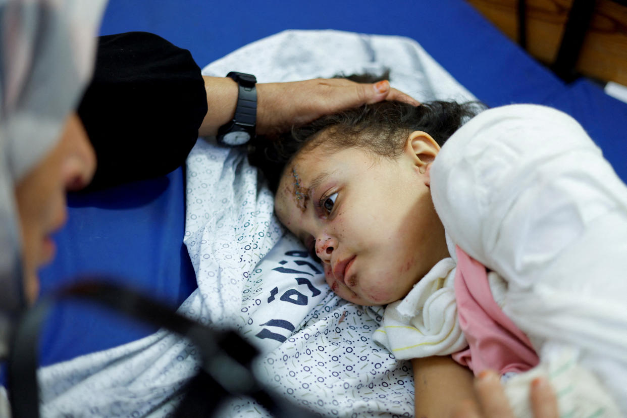 Palestinian girl Fulla Al-Laham, 4, who was wounded in an Israeli strike that killed 14 family members, including her parents and all her siblings, lies on a bed as her grandmother sits next to her, at a hospital in Khan Younis in the southern Gaza Strip, October 14, 2023. REUTERS/Mohammed Salem     TPX IMAGES OF THE DAY
