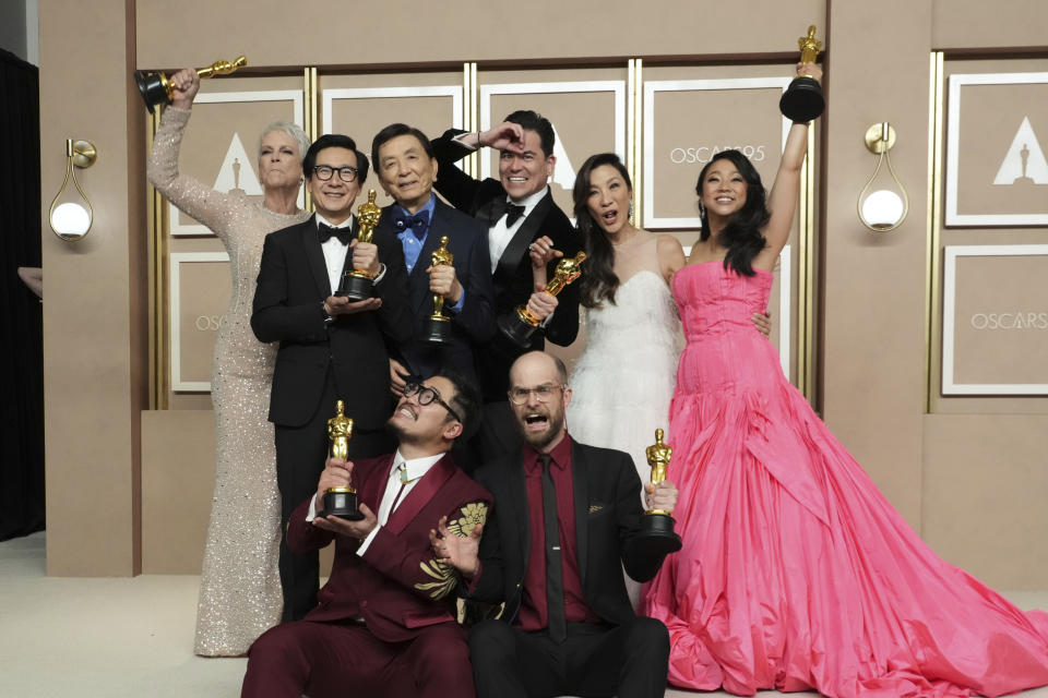 Jamie Lee Curtis, from back left, Ke Huy Quan, James Hong, Jonathan Wang, Michelle Yeoh, and Stephanie Hsu, Daniel Kwan, left front, and Daniel Scheinert, winners of the award for best film for "Everything Everywhere All at Once," pose in the press room at the Oscars on Sunday, March 12, 2023, at the Dolby Theatre in Los Angeles. (Photo by Jordan Strauss/Invision/AP)