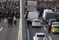 Protesters stand on the highway during a protest in Belgrade, Serbia, Saturday, Dec. 4, 2021. Thousands of protesters have gathered in Belgrade and other Serbian towns and villages to block roads and bridges despite police warnings and an intimidation campaign launched by authorities against the participants. Thousands of protesters have gathered in Belgrade and other Serbian towns and villages to block roads and bridges despite police warnings and an intimidation campaign launched by authorities against the participants. (AP Photo/Darko Vojinovic)