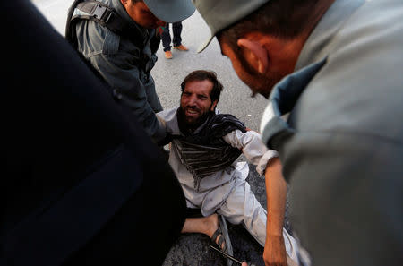 Afghan police officers comfort a man, after he received news of his relatives being among the victims, at the site of a suicide attack, in Kabul, Afghanistan September 13, 2017.REUTERS/Mohammad Ismail