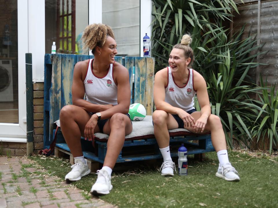 Celia Quansah and Megan Jones sit next to each other and smile at each other