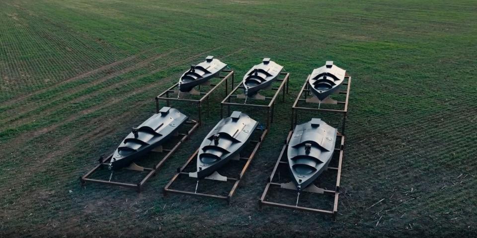 A picture of Ukrainian drone boats sitting on a grass field.