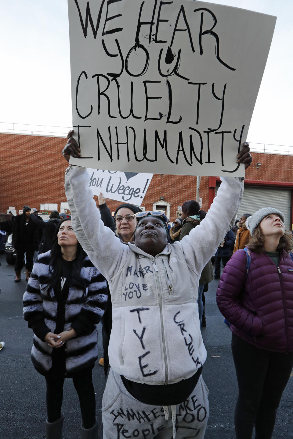 Caren Burton, of Bayshore, Long Island, holds a sign so her incarcerated son Tyrone Robinson can see it as she protests jail conditions from outside the Metropolitan Detention Center Sunday, Feb. 3, 2019, in New York. Prisoners have been without heat, hot water, electricity and sanitation due to an electrical failure since earlier in the week, including during the recent frigid cold snap. (AP Photo/Kathy Willens)