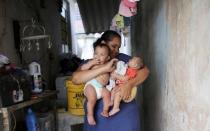 Jaqueline (L), 25, holds her five-month-old twins, Laura (R) and Lucas at their house in Santos, Sao Paulo state, Brazil April 20, 2016. REUTERS/Nacho Doce