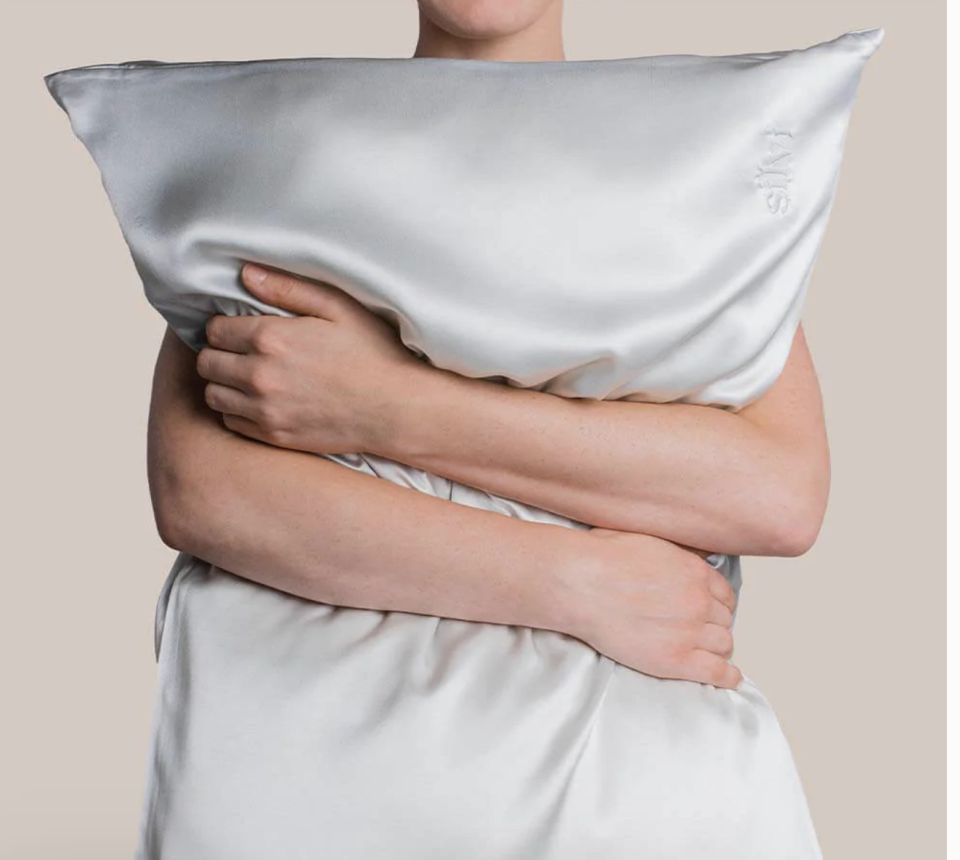 Person hugging pillow in a Silvi silver pillowcase