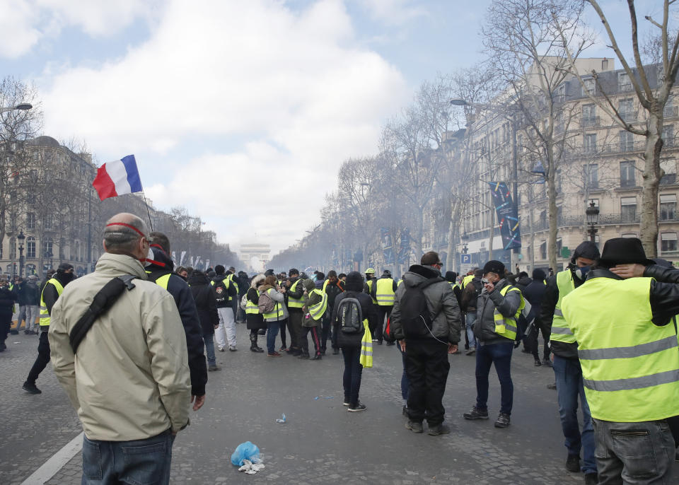 Yellow vests protesters gather on the Champs Elysees avenue Saturday, March 16, 2019 in Paris. French yellow vest protesters clashed Saturday with riot police near the Arc de Triomphe as they kicked off their 18th straight weekend of demonstrations against President Emmanuel Macron. (AP Photo/Christophe Ena)