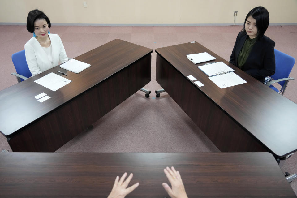 Prosecutors Tomoko Suzuki, left, and Rina Ito listen questions from a reporter during an interview at Tokyo District Public Prosecutors Office on Feb. 27, 2023, in Tokyo. Twenty years ago, only about 8% of Japanese prosecutors were women. By 2018, that number rose to nearly a third of newly hired prosecutors. This year, the male-female ratio reached 50-50, according to the Tokyo District Prosecutors Office. (AP Photo/Eugene Hoshiko)