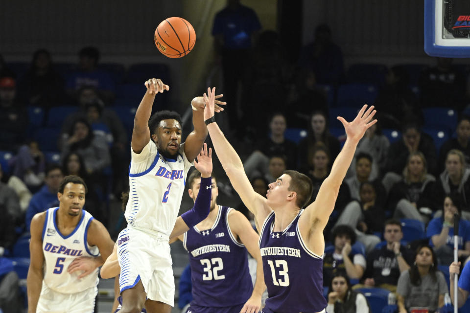 DePaul guard Chico Carter Jr. (2) passes the ball away from Northwestern guard Brooks Barnhizer (13) during the first half of an NCAA college basketball game, Saturday, Dec. 16, 2023, in Chicago. (AP Photo/Matt Marton)