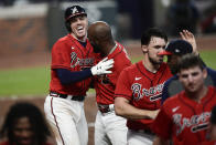 Atlanta Braves' Freddie Freeman, top left, celebrates his winning two-run home with teammates during the 11th inning of a baseball game against the Boston Red Sox, Friday, Sept. 25, 2020, in Atlanta. (AP Photo/John Amis)