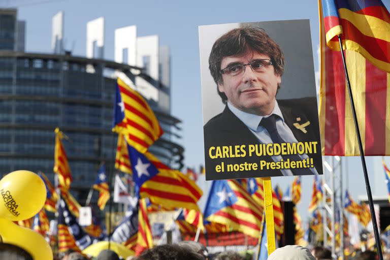 Manifestantes levantan un cartel del expresidente regional catalán Carles Puigdemont afuera del Parlamento Europeo en Estrasburgo, Francia. (AP Foto/Jean-Francois Badias)