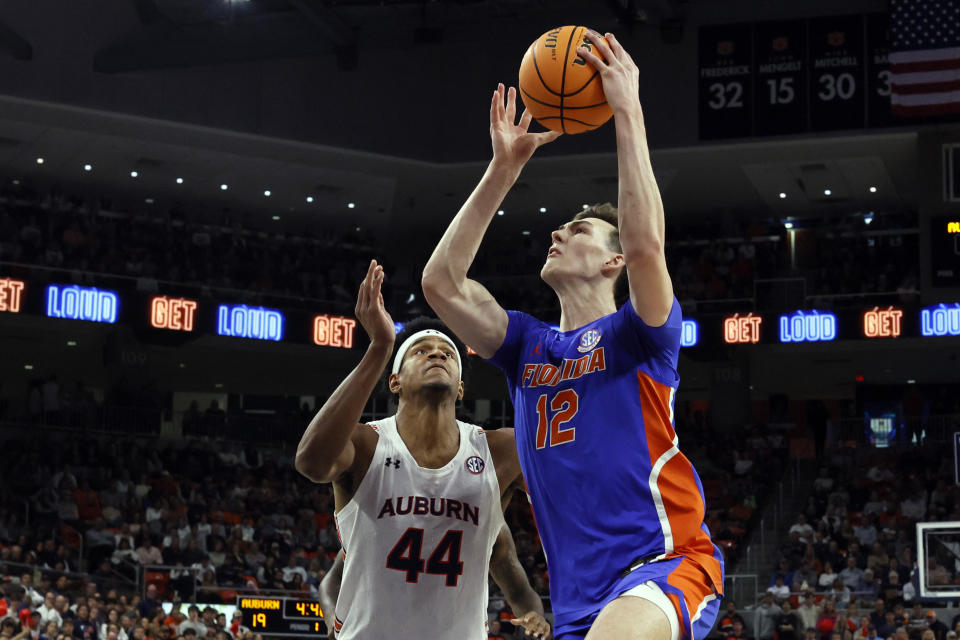 Florida forward Colin Castleton (12) goes up for a lay up as Auburn center Dylan Cardwell (44) defends during the first half of an NCAA basketball game Wednesday, Dec. 28, 2022, in Auburn, Ala. (AP Photo/Butch Dill)