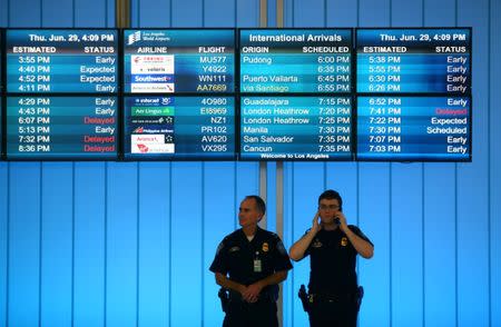 U.S. Customs and Immigration officers keep watch at the arrivals level at Los Angeles International Airport in Los Angeles, California, U.S., June 29, 2017. REUTERS/Mike Blake