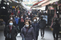 People wearing face masks as a precaution against the coronavirus walk through a market in Seoul, South Korea, Friday, Nov. 27, 2020. South Korea's daily virus tally hovered above 500 for the second straight day, as the country's prime minister urged the public to stay home this weekend to contain a viral resurgence. (AP Photo/Ahn Young-joon)